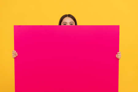 place for promotion and creativity. your marketing design. hiding teen girl with advertisementの写真素材