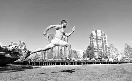 Run fast. Energetic guy run outdoors. Man runner in sportswear. Summer sports. Running jump