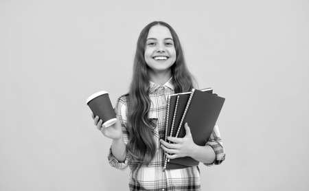 knowledge day. kid in checkered shirt with notebook and tea cup on yellow background.の写真素材