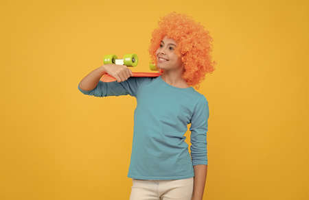 skateboarder. cheerful child holding penny board. teen girl with fancy hairstyle.