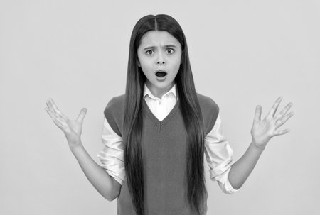 shocked teen school girl smiling with long hair on yellow background, shockの写真素材