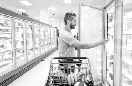 happy man with shopping cart. customer consumer with purchases. guy at grocery store.