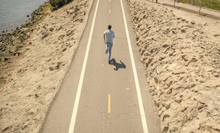 mature athletic man running on road outdoor, marathon