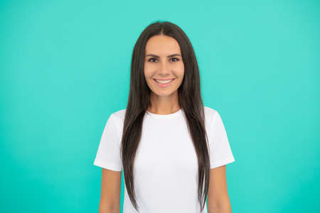 cheerful young woman in white shirt on blue backgroundの写真素材