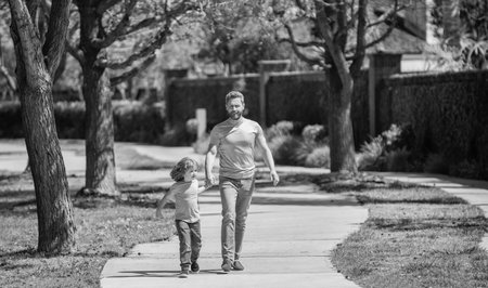 cheerful dad with kid relax together in park, family walkの写真素材