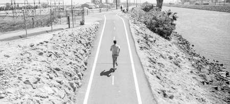 mature athletic man running on road outdoor, sprinter