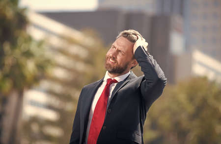 bearded businessman looking up on urban background, business man.の写真素材