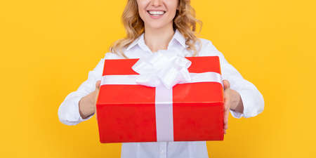 happy woman with big present box on yellow background