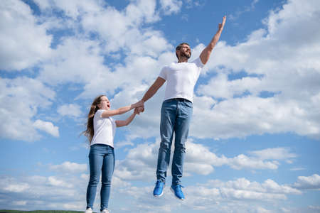 daughter hold her dad jumping in skyの写真素材
