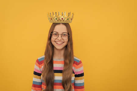 happy child in glasses wear queen crown on yellow background, victoryの写真素材