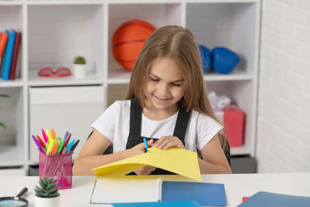 cheerful child cut paper in school classroomの写真素材