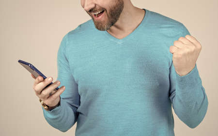 happy man with beard watching and reading smartphone, mobile deviceの写真素材
