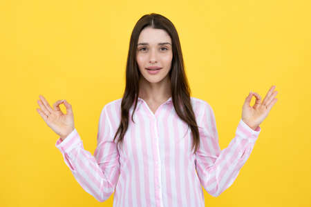 Portrait of attractive cheerful dreamy focused woman meditating. Young woman girl hold hands in yoga gesture relaxing meditating. Mindful peaceful woman meditates, keeps hands in mudra gesture.の写真素材