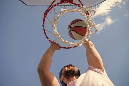 basketball player throws the ball into the hoop outdoor, targetingの写真素材