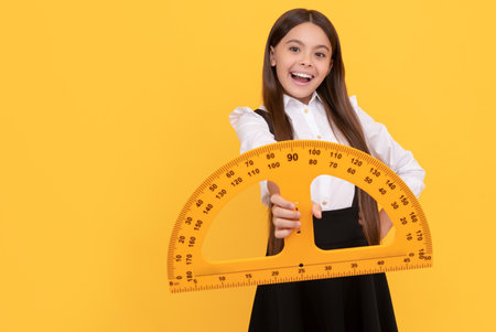amazed kid in school uniform hold mathematics protractor for measuring, logicの写真素材