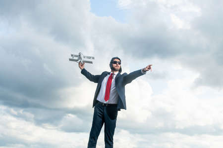 businessman in suit and pilot hat launch plane toy on sky background. leadershipの写真素材