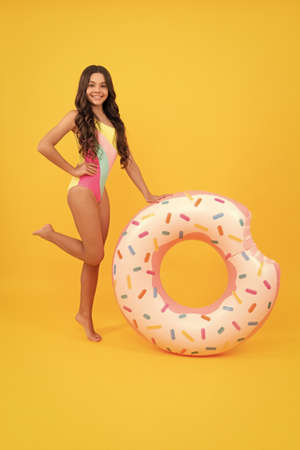 cheerful girl in swimsuit inflatable doughnut ring. teen with swimming ring.の写真素材