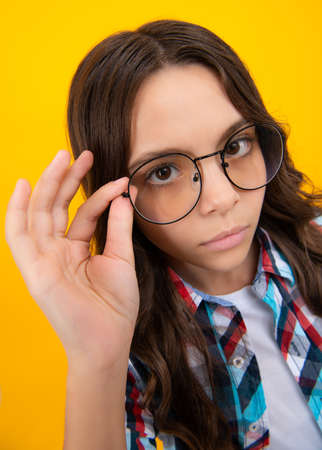 Ophthalmologist tries on eyeglasses of teenager little girl, close-up. Treatment of childrens vision with glasses.の写真素材