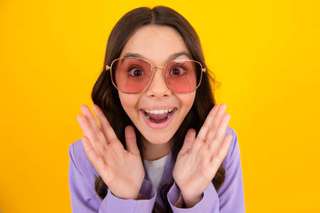 Amazed teen girl. Excited expression, cheerful and glad. Headshot portrait of cute teenager child...