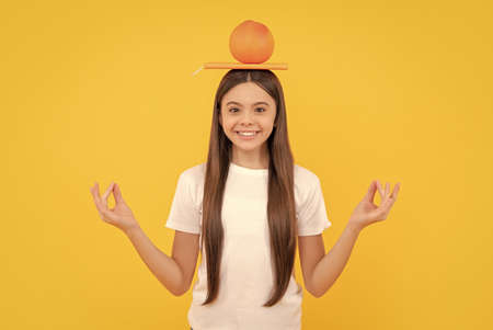 happy kid hold grapefruit and book on yellow background, vitaminの写真素材
