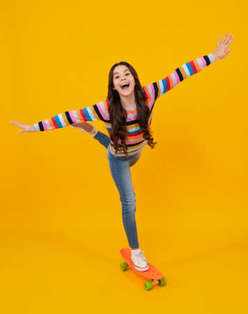 Amazed teenager. Teenagers youth casual culture. Teen girl with skateboard over isolated studio background. Teenager in fashion stylish clothes. Excited teen girl.の写真素材