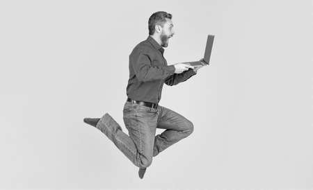 surprised energetic jumping man running working online on laptop hurry up for shopping, business