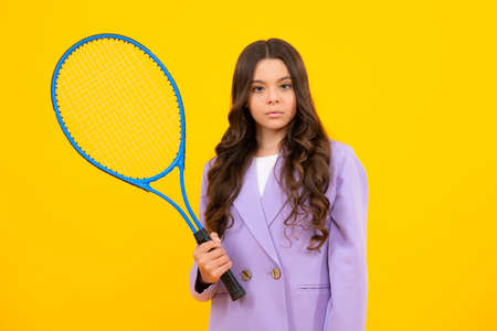 Tennis player hold tennis racket over isolated yellow studio background. Sport and fitness for kids....