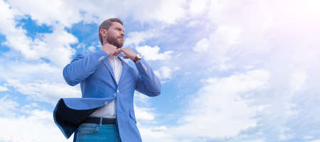 Man face portrait, banner with copy space. Business man in suit, blue sky background. male formal fashion. professional unshaven ceo. man bride groom on sky background.の写真素材