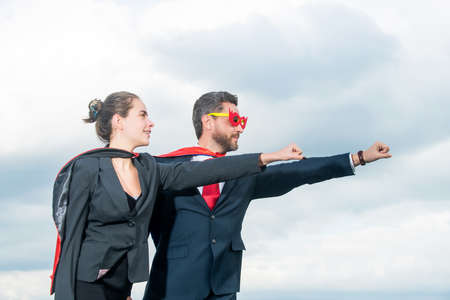 business couple in superhero suit on sky backgroundの写真素材