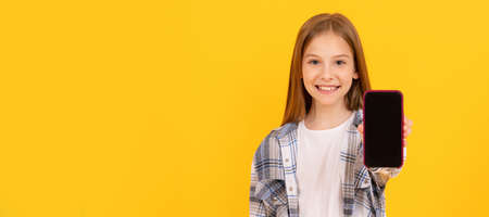happy kid presenting product of modern smartphone show screen for copy space, advertisement. Child...