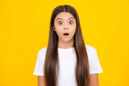 Shocked teenager child portrait isolated on yellow background. Surprised teenage girl. Amazed...