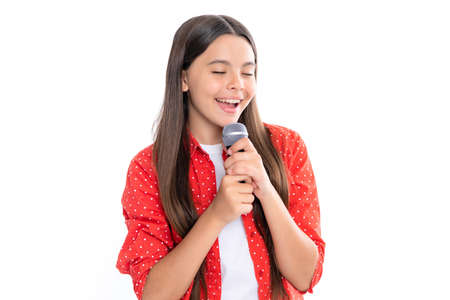 Happy cute teen girl singing a song on microphone. Close-up portrait of trendy fashionable girl singing karaoke.の写真素材