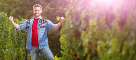 happy vinedresser standing at winery farm, harvesting. Man face portrait, banner with copy space.