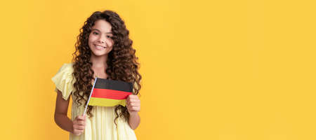smiling kid long curly hair hold german flag, germany. Horizontal poster of isolated child face, banner header, copy space.の写真素材
