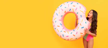 child hold beach accessory of inflatable circle. active childhood. summertime kid weekend. Banner of summer child girl in swimsuit, studio poster header with copy space.の写真素材