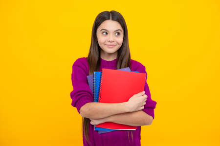 Funny face. Teenager school girl with books isolated studio background.の写真素材