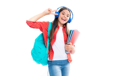 School girl, teenage student in headphones hold books on white isolated studio background. School and music education concept.の写真素材