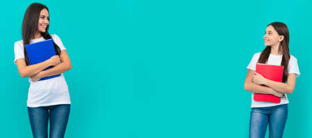 Mother and daughter child banner, copy space, isolated background. mom and teen girl study. private teacher and child holding copybooks. family help.の写真素材