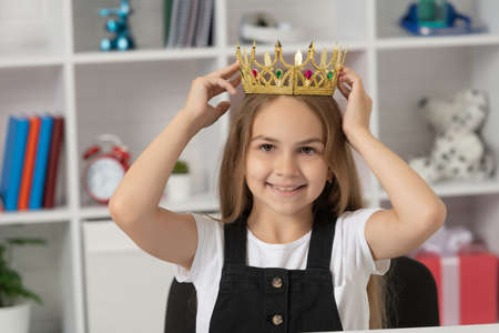 happy kid wearing queen crown at school classroomの写真素材