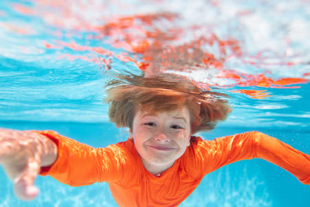 Child swim and dive underwater in the swimming pool.の写真素材