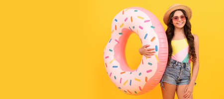 Summer child. happy beach kid in straw hat and sunglasses with doughnut inflatable ring, summer vacation. Banner of summer child girl in swimsuit, studio poster header with copy space.の写真素材