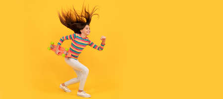 Run and jump. energetic kid skateboarder in colorful clothes. penny skateboard. skateboarding. Casual teen child horizontal poster. Banner header, copy space.の写真素材