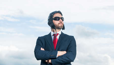 businessman in suit and pilot hat crossed hands on sky background