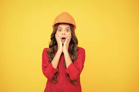 future engineer. making repairs. surprised teen girl in protective hard hat.