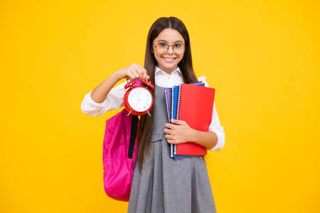 School teen girl checking time. Schoolgirl with clock alarm. School time.