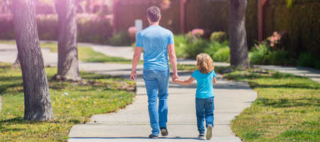 Banner of father and son walk in park back view. family value. childhood and parenthood.の写真素材