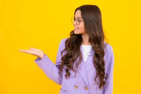 Impressed teenage girl showing recommendation copyspace. Child teenager points away, pointing aside at copy space.の写真素材