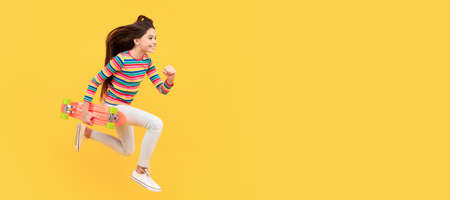 Run and jump. happy energetic child skateboarder jumping with penny board skateboard, childhood. Casual teen child horizontal poster. Banner header, copy space.の写真素材