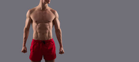 Man sexy bare torso, banner with copy space. Sport fan. Sportsman with six pack abs. Muscular man grey background. Sport and fitness.の写真素材