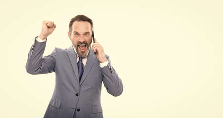 happy grizzled business man in suit speaking on phone isolated on white copy space, business successの写真素材